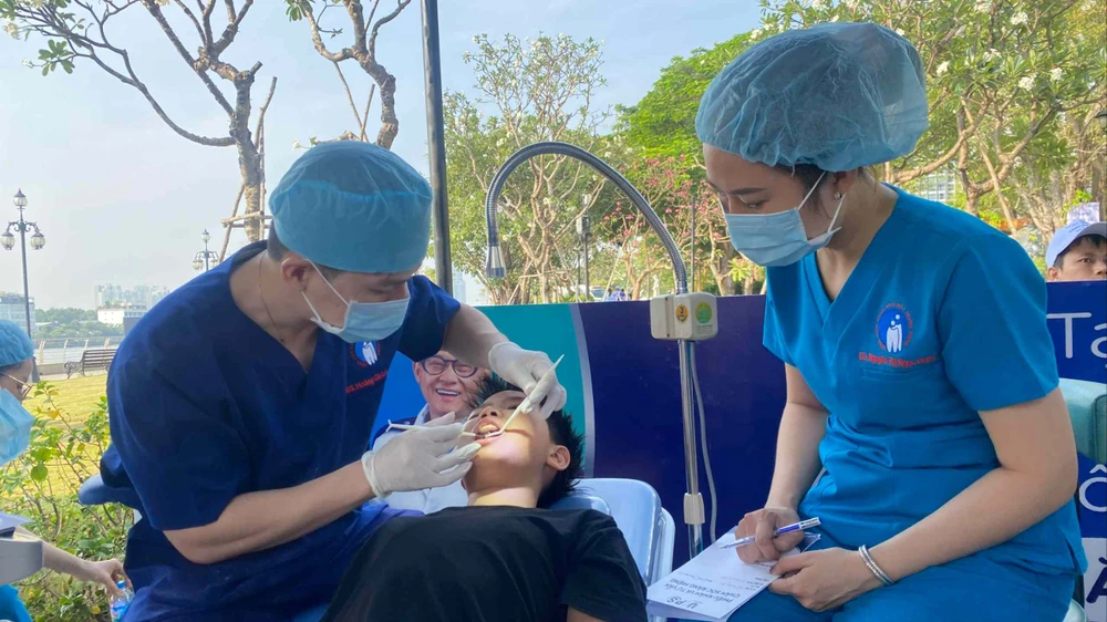 Ein Arzt im Zentralkrankenhaus für Odonto-Stomatologie in Ho-Chi-Minh-Stadt untersucht die Zähne eines Studenten.