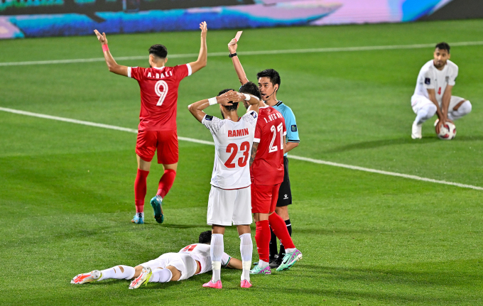 Referee Kim Jong-hyeok shows a red card to Mehdi Taremi who is lying on the ground after tackling No. 9 Alaa Al Dali. Photo: AFC