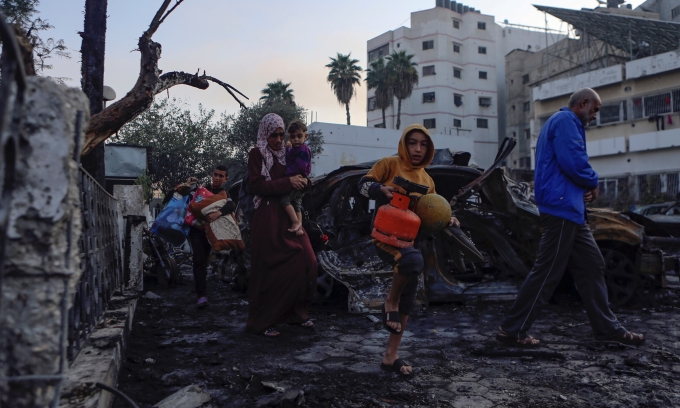 Người dân Palestine bước qua đống đổ nát của bệnh viện Al-Ahli, miền trung Dải Gaza, ngày 18/10. Ảnh: AP