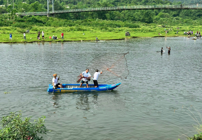 សមាជិកក្រុមឈរនៅលើទូកអួនដើម្បីចាប់ត្រី។ រូបថត៖ ហុង ឡឺ