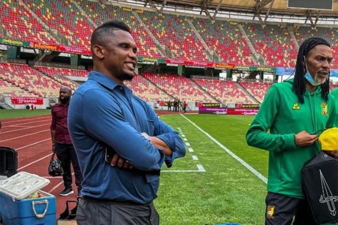 Etoo stand im März 2022 mit verschränkten Armen am Spielfeldrand eines Spiels für Kamerun. Foto: Fecafoot