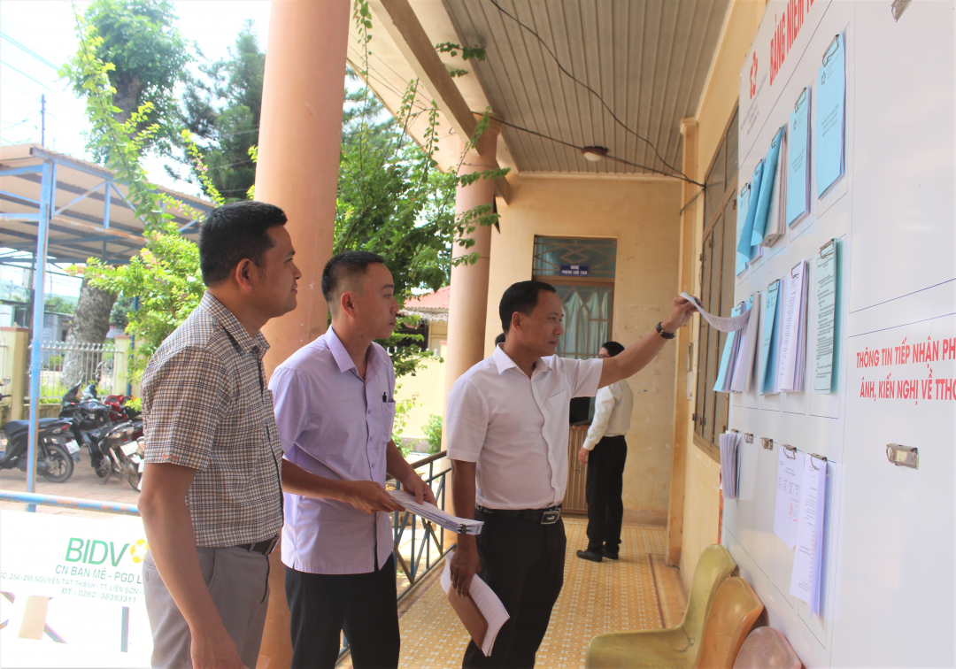 Members of the Inspection Team review the public disclosure of administrative procedures at the People's Committee of Nam Ka commune.