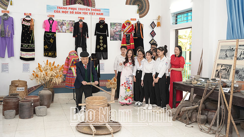 Lehrer Doan Van Thoai von der Quang Trung High School (Nam Truc) stellt den Schülern die Produktionswerkzeuge unserer Vorfahren in der Vergangenheit vor.