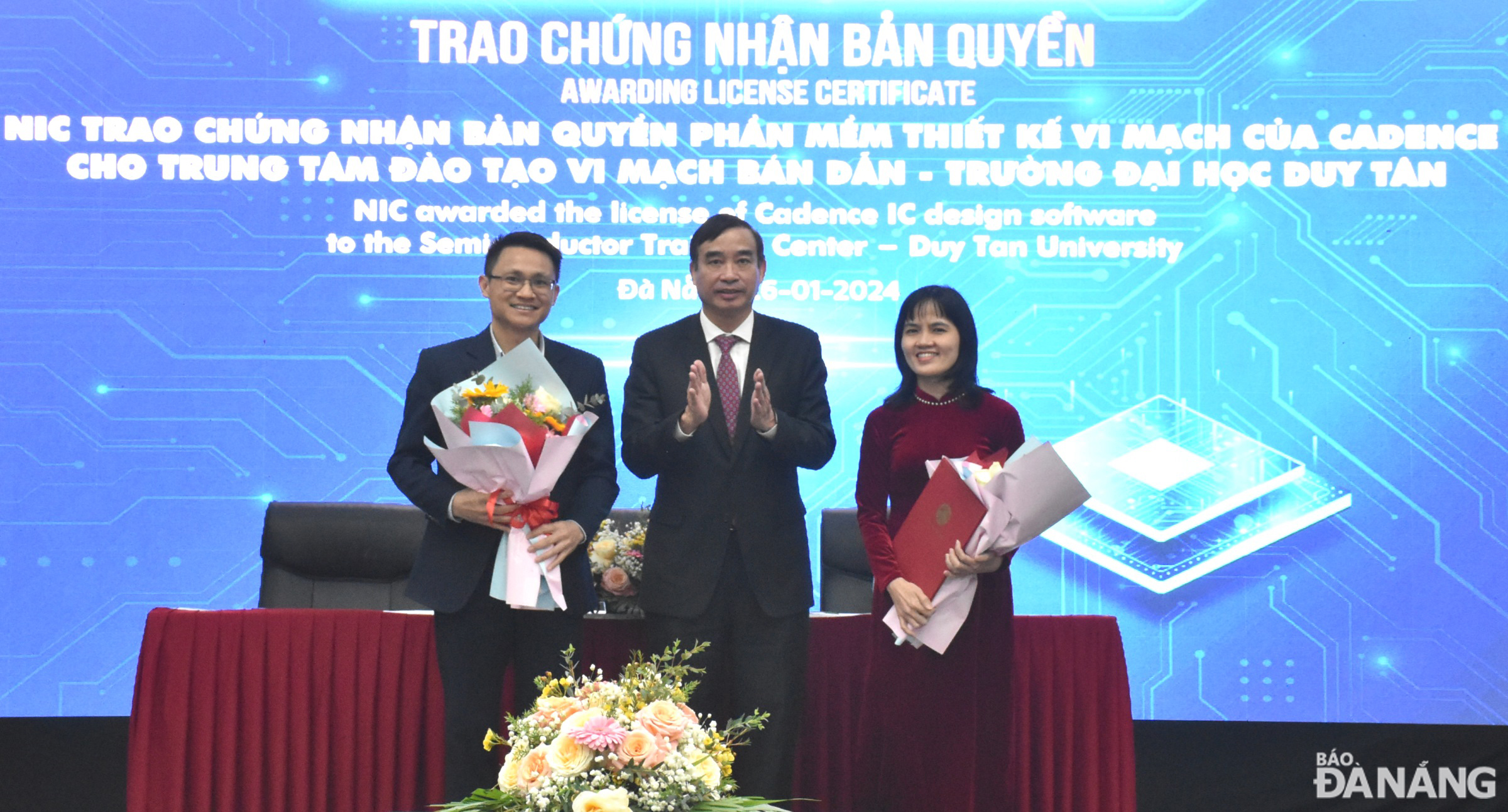 Chairman of the City People's Committee Le Trung Chinh (middle) presented a congratulatory gift to Duy Tan University's Semiconductor Training Center for receiving a copyright certificate for Cadence's microchip design software. Photo: HOANG HIEP - THU HA