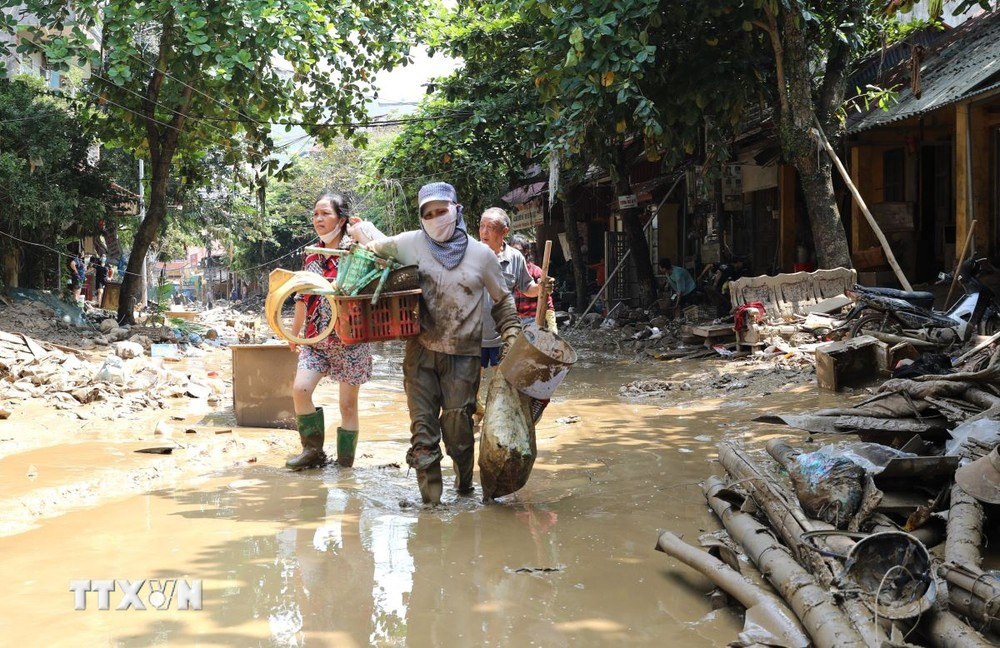 Am Nachmittag des 14. September müssen die Menschen immer noch durch Schlamm waten, wenn sie sich in den Straßen Thanh Nien und Tran Hung Dao in Yen Bai bewegen. (Foto: Tuan Anh/VNA)