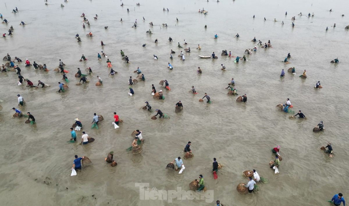 気温16度の寒い中、何百人もの人々が幸運を祈って魚を捕まえるために畑へ出かけます（写真11）