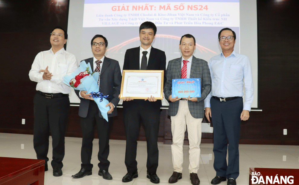 Mr. Vu Quang Hung (right cover), Head of the Management Board of Da Nang High-Tech Park and Industrial Zones and Mr. Nguyen Minh Huy (left cover), Director of the Management Board of Da Nang Traffic Construction Investment Projects, presented the award to the first prize winner of the contest. Photo: TRONG HUNG