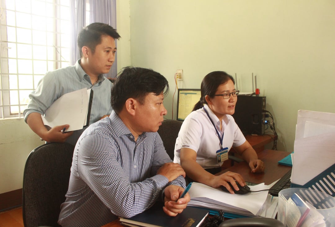 Members of the Inspection Team compare records and documents at the People's Committee of Bang Adrenh commune.