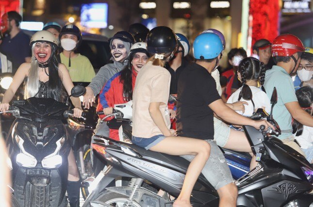 Junge Menschen werden in der Halloween-Nacht mit eindrucksvollen Kostümen umringt und fotografiert. Foto 11