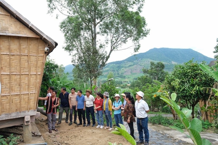 Hướng dẫn viên tại Làng kháng chiến Stơr, xã Tơ Tung, huyện Kbang giới thiệu cách làm nhà sàn của người Bahnar với đoàn khảo sát. Ảnh: HOÀNG NGỌC