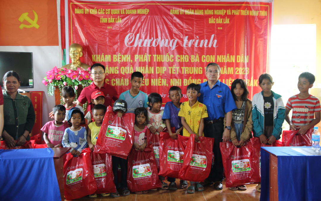 Các cháu thiếu niên, nhi đồng của buôn kết nghĩa nhận quà tại chương trình.