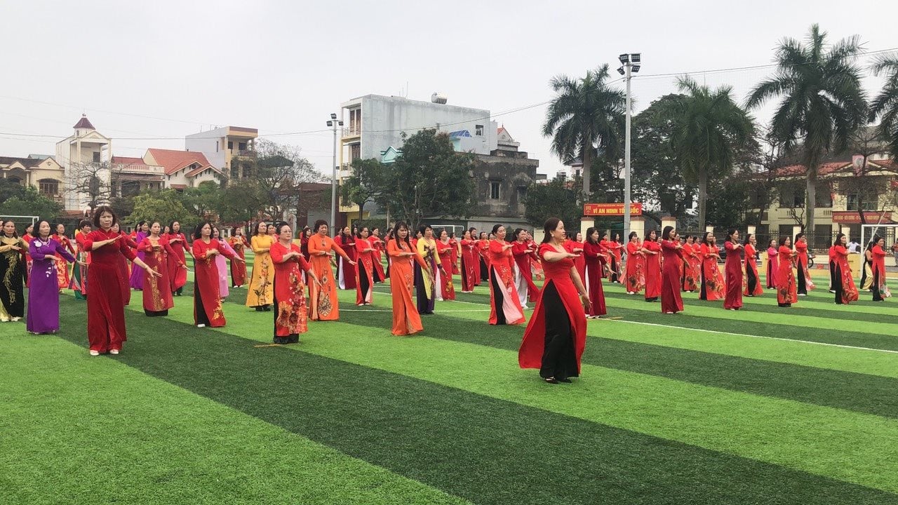 Casi 200 mujeres del barrio de Thanh Binh actúan en ao dai