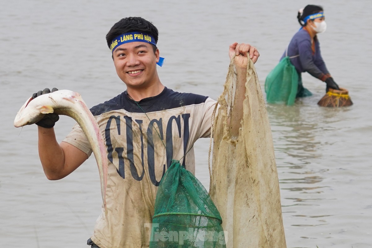 気温16度の寒い中、何百人もの人々が幸運を祈って魚を捕まえるために畑に出かけます（写真9）