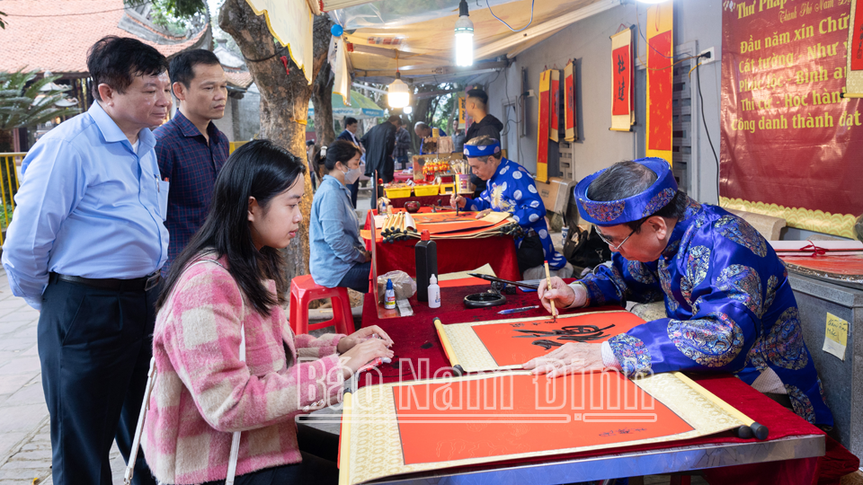 ครูสอนเขียนพู่กันในเทศกาลเปิดตราประทับวัดทราน ปี 2567