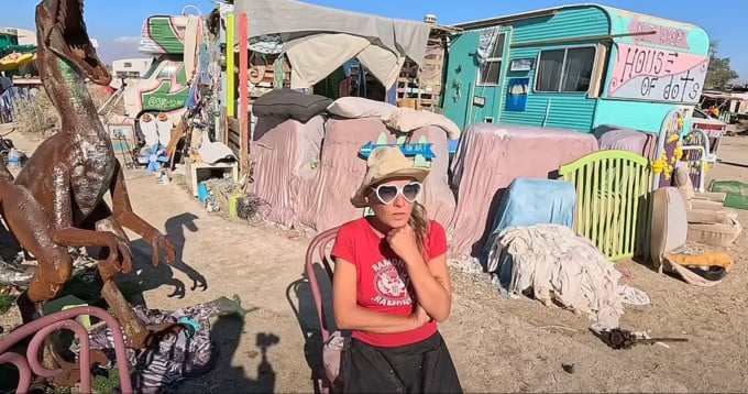 Dot, una residente de Slab City, está sentada frente a su casa. Foto cortada del vídeo