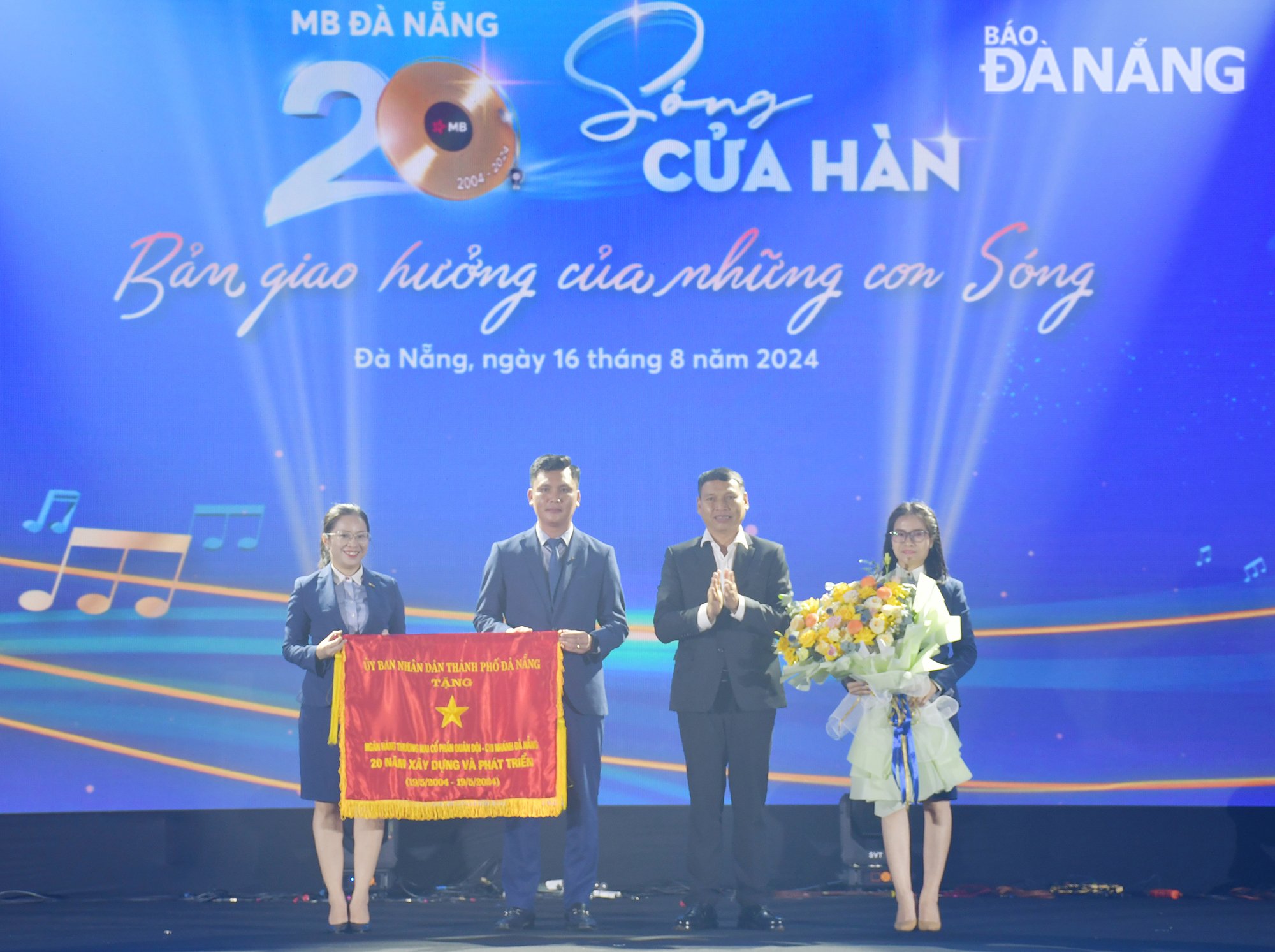 El vicepresidente permanente del Comité Popular de la Ciudad, Ho Ky Minh, presentó la bandera en reconocimiento a los logros y contribuciones de desarrollo de 20 años del Banco Militar, sucursal Da Nang. Foto: THANH LAN