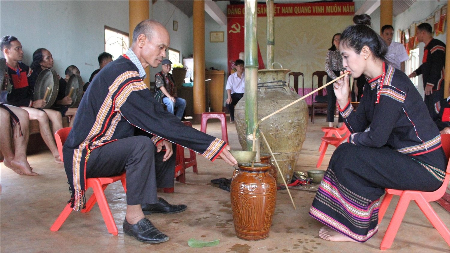 Bà con buôn làng uống rượu cần sau khi nghi thức cúng đầu tiên (cúng tổ tiên)