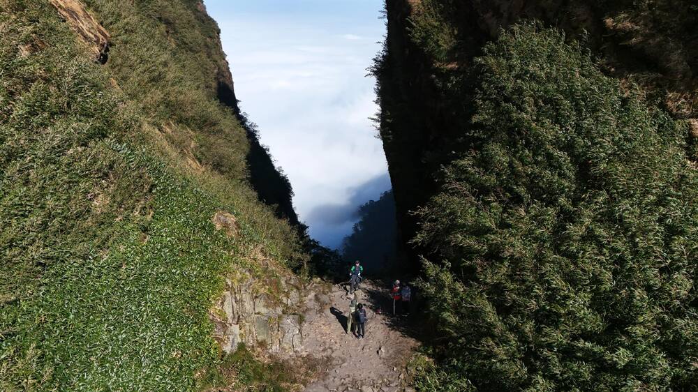 Der Aufstieg zum Gipfel des Ngu Chi Son dauert schätzungsweise 12 km und führt hauptsächlich über Pfade durch Urwälder oder entlang einer Reihe hoher, felsiger Berge, die sich in den Wolken wölben. Foto: NVCC