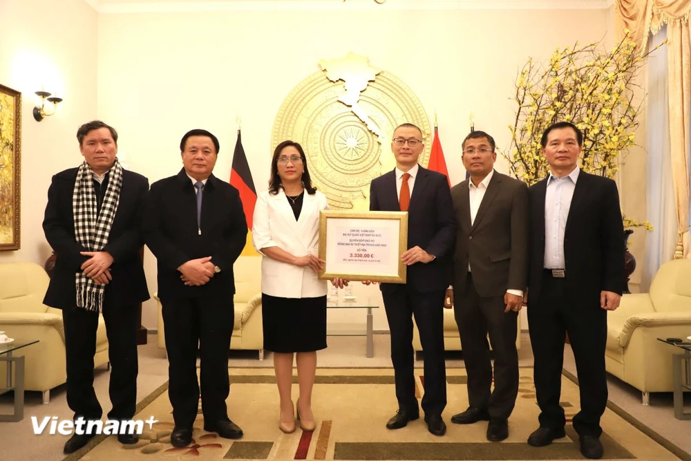 Botschafter Vu Quang Minh übergab der Delegation unter der Leitung von Herrn Nguyen Xuan Thang (zweiter von links), Mitglied des Politbüros, Vorsitzender des Zentralen Theoretischen Rates und Direktor der Nationalen Akademie für Politik Ho Chi Minh, symbolisch 3.330 Euro zur Übergabe an die Flutopfer in Vietnam. (Foto: Phuong Hoa/Vietnam+)