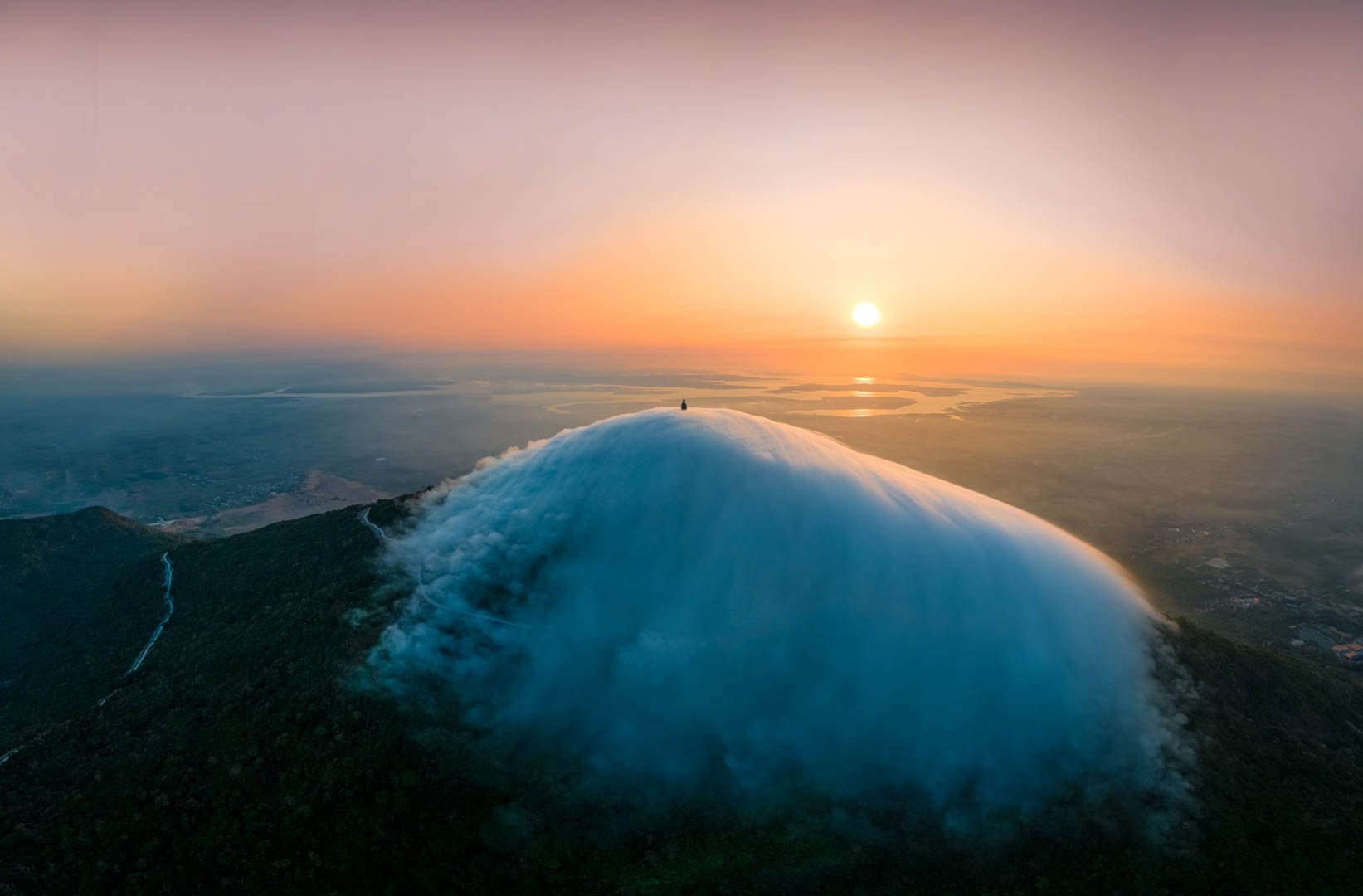 Un mar de nubes blancas aparece sobre la montaña Ba Den, una escena surrealista que provoca fiebre.