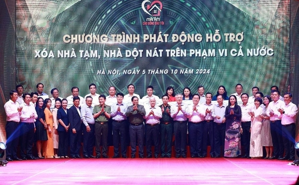 Prime Minister Pham Minh Chinh with representatives of organizations and businesses providing funding to remove temporary and dilapidated houses. (Photo: Duong Giang/VNA)