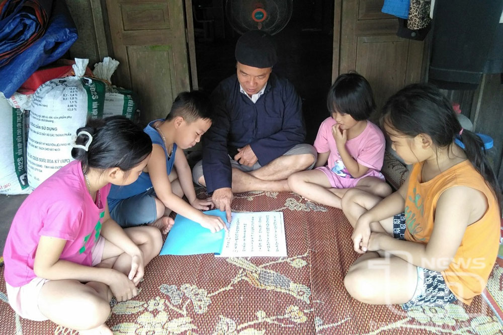 Ông Chu Văn Cam dạy các cháu nội, ngoại chữ Hán cổ.
