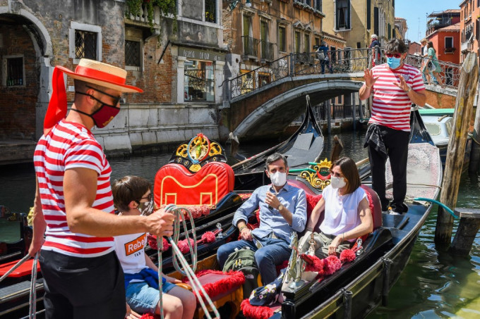 Touristen machen eine Bootstour durch die Kanäle in Venedig, Italien. Foto: AFP