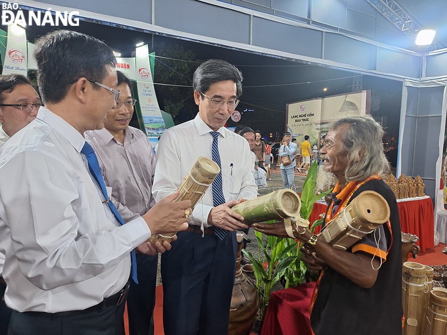 Le vice-président du Comité populaire de la ville, Tran Chi Cuong (deuxième à partir de la droite), a visité les stands d'exposition de la province de Ninh Thuan lors de l'événement. Photo : THU HA