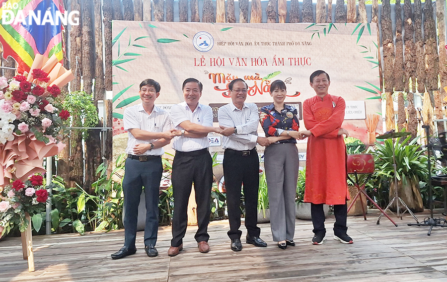 តំណាងនាយកដ្ឋានទេសចរណ៍ Truong Thi Hong Hanh (ទីពីរពីស្តាំ) និងអង្គភាពពាក់ព័ន្ធបានកាន់ដៃគ្នាដោយសន្យាថានឹងអភិវឌ្ឍមុខម្ហូបទៅជាផលិតផលទេសចរណ៍។ រូបថត៖ THU HA