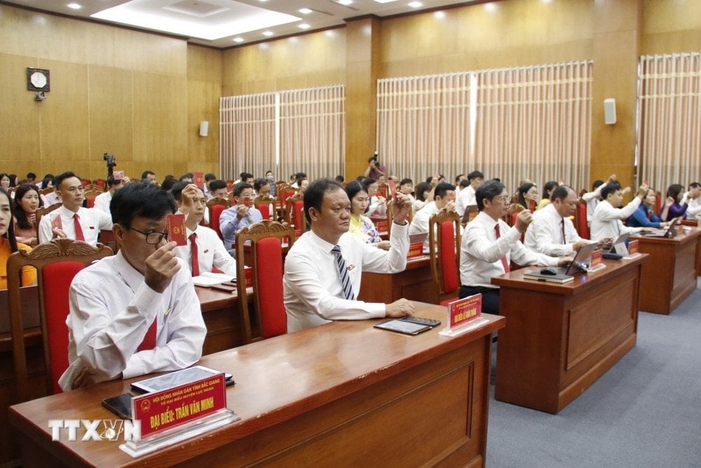 Delegates vote to pass a resolution on personnel work. (Photo: VNA)