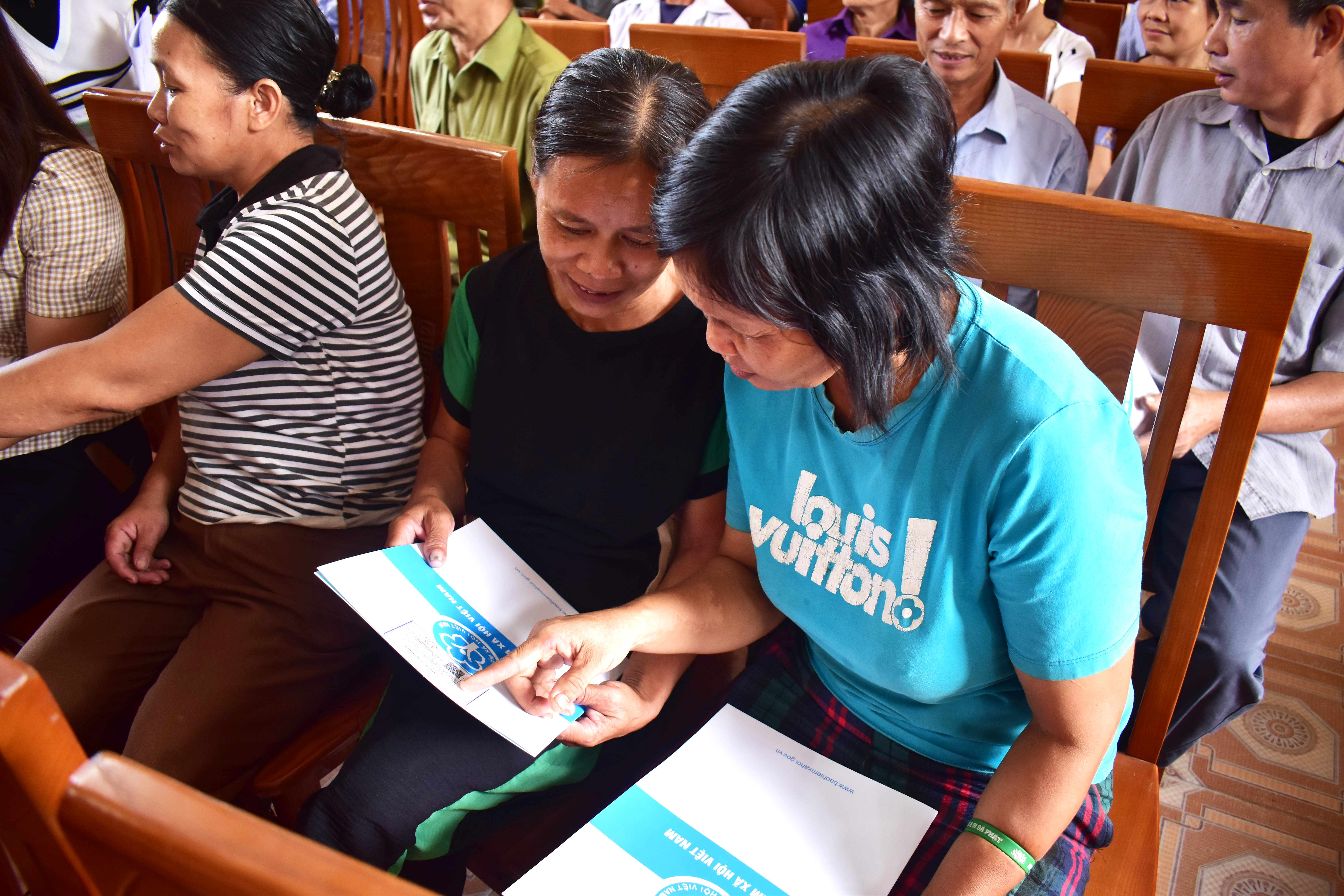 Presentación de libretas de seguro social y tarjetas de seguro médico en el distrito de Ha Hoa