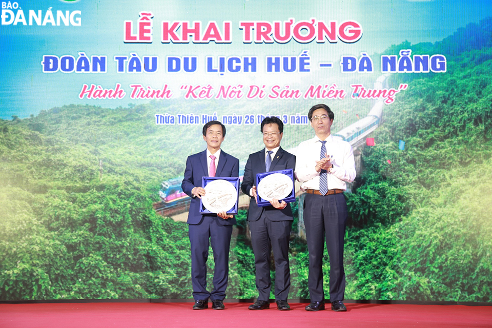 Vice Chairman of Da Nang People's Committee Tran Chi Cuong (far right) presents souvenirs to Chairman of Thua Thien Hue Provincial People's Committee and Chairman of the Board of Members of Vietnam Railway Corporation. Photo: CHIEN THANG