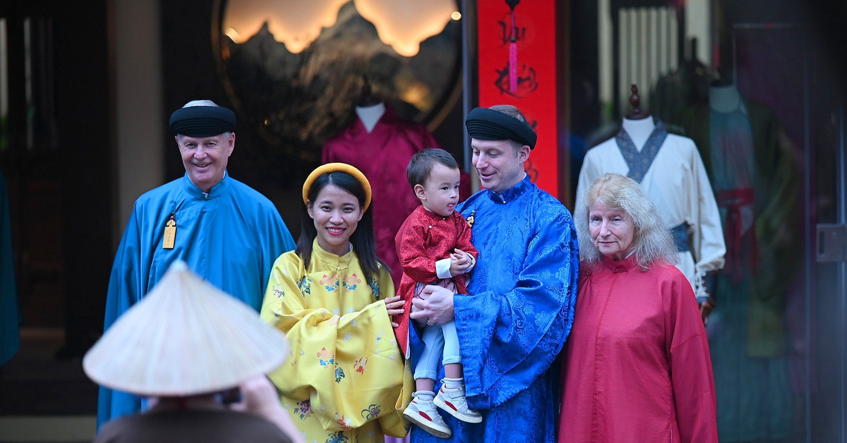 Des touristes occidentaux portant des costumes traditionnels vietnamiens, fascinés par l'expérience du vieux Têt au pied de la montagne Yen Tu