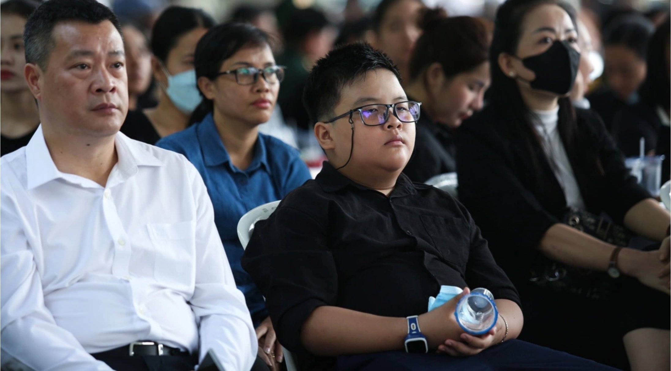 Tomando prestada la camisa negra de su abuela, un niño de 12 años visitó al Secretario General Nguyen Phu Trong en Ciudad Ho Chi Minh.