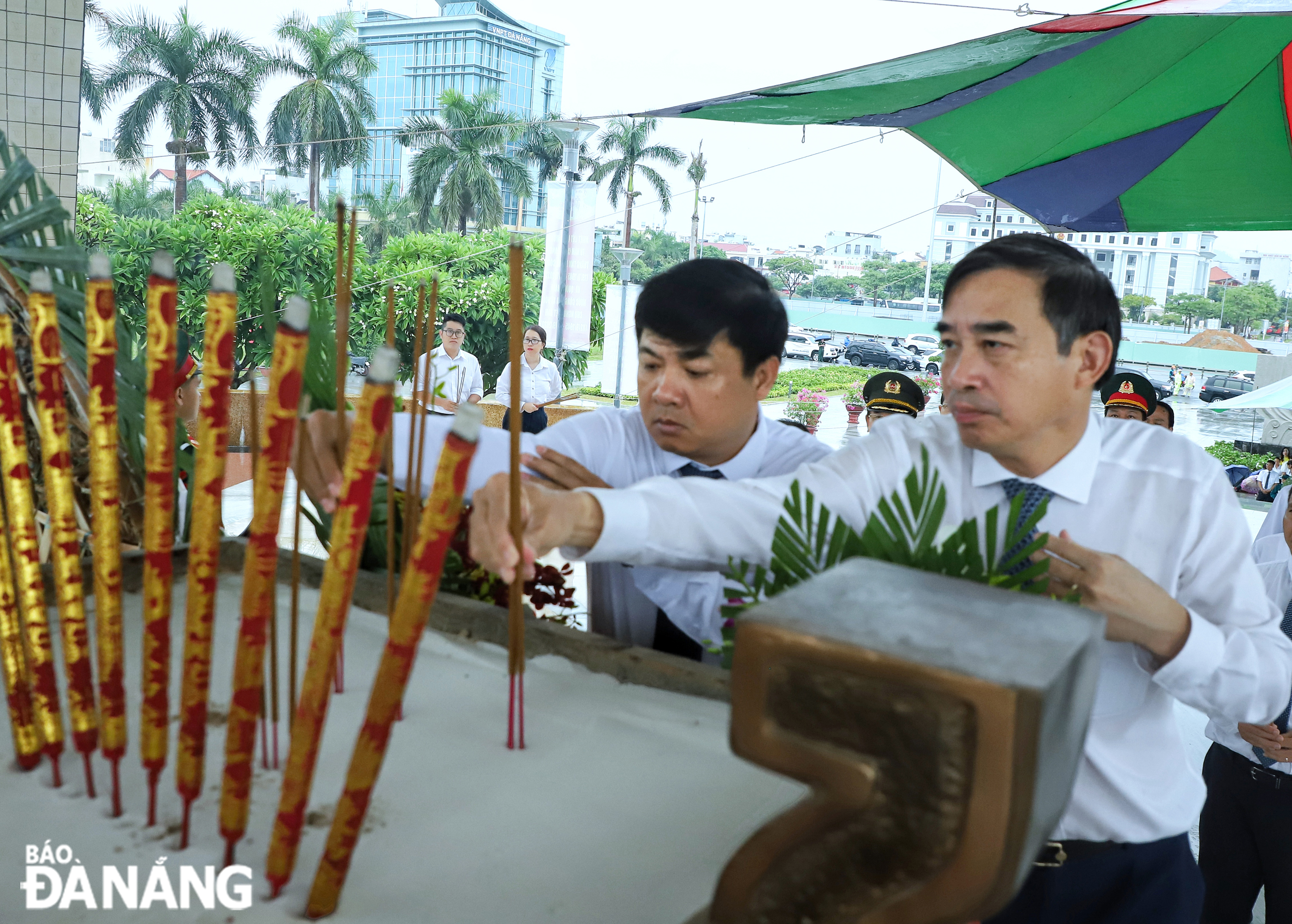เล จุง จิ่ง รองเลขาธิการคณะกรรมการพรรคประจำเมือง เลือง เหงียน มินห์ เตรียต (ซ้าย) และเล จุง จิ่ง ประธานคณะกรรมการประชาชนเมือง (ขวา) จุดธูปรำลึกถึงวีรบุรุษและผู้เสียสละ ภาพ: NGOC PHU