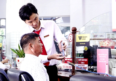 Agribank staff support customers to perform biometric authentication.