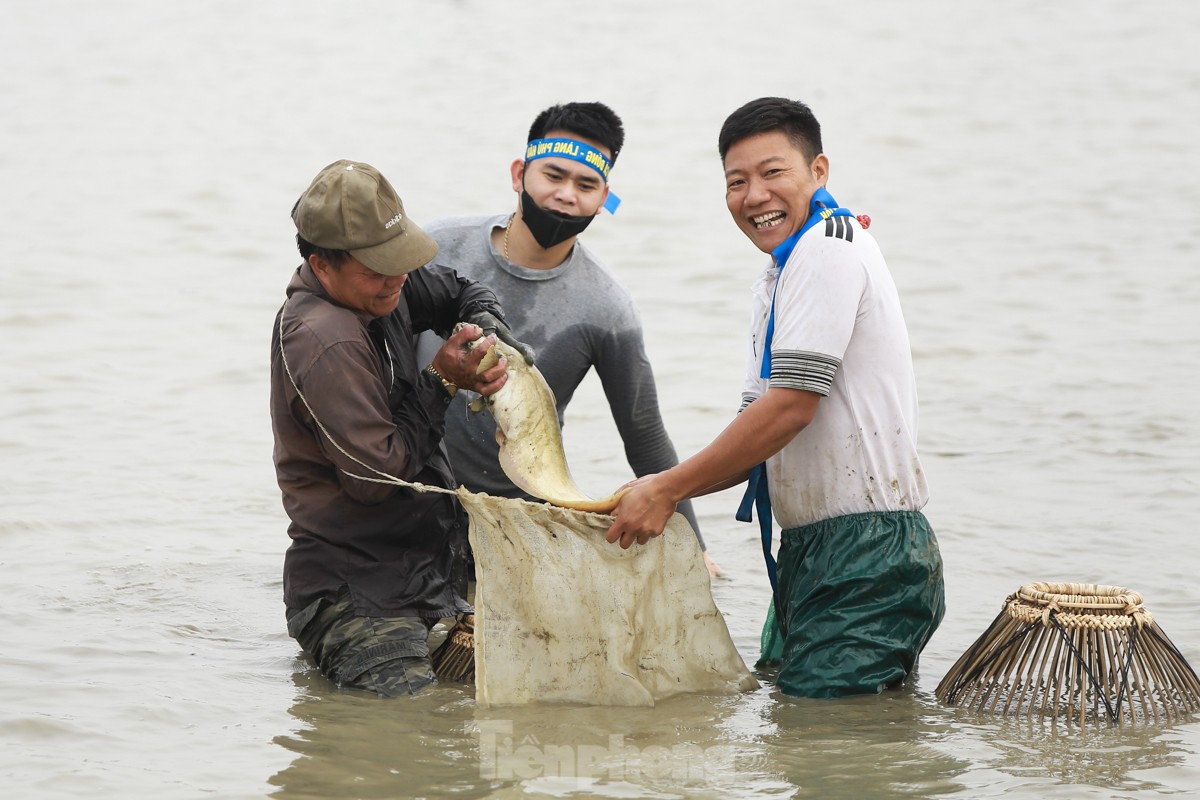 気温16度の寒い中、何百人もの人々が幸運を祈って魚を捕まえるために畑へ出かけます（写真8）