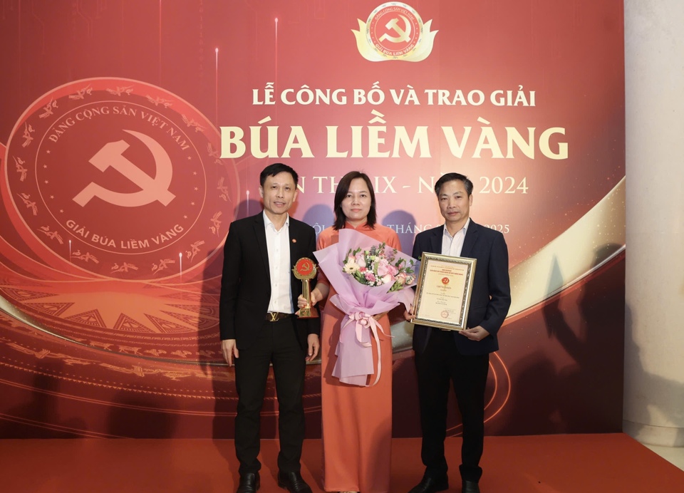 El editor jefe del periódico Economic & Urban, Nguyen Thanh Loi, felicita a los autores premiados