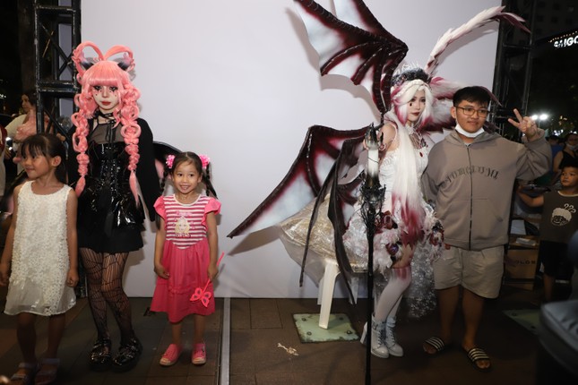 Junge Menschen sind umgeben, um Fotos mit beeindruckenden Kostümen in der Halloween-Nacht zu machen Foto 5