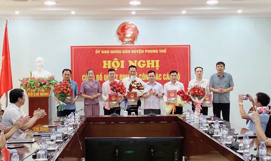Các đồng chí lãnh đạo UBND huyện trao quyết định về công tác cán bộ và tặng hoa chúc mừng 5 đồng chí.