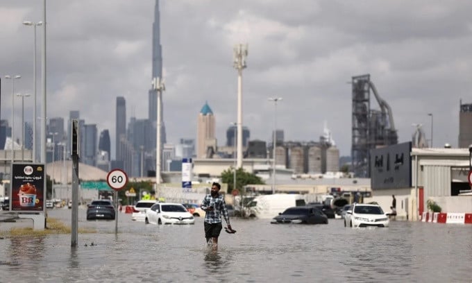 Ein Mann geht am 17. April durch die Fluten in Dubai (VAE), im Hintergrund ist der Burj Khalifa zu sehen. Foto: Reuters