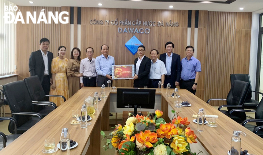 El director del Departamento de Construcción, Phung Phu Phong (cuarto desde la derecha), entrega obsequios del Tet a los líderes de la Compañía Anónima de Abastecimiento de Agua de Da Nang. Foto: GIA PHUC