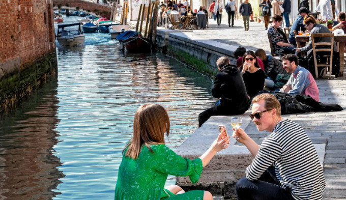 Tourists take souvenir photos by the canal in Venice. Photo: Euro News