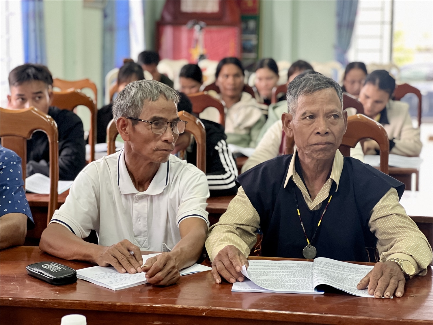 Già làng, Người có uy tín Đinh Ponh (bên phải ảnh) luôn trau dồi kiến thức, phát huy vai trò của mình trong những công việc chung của làng, của xã