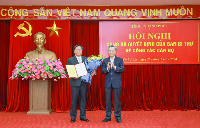 Deputy Head of the Central Organization Committee Nguyen Quang Duong presents the decision of the Secretariat to Mr. Tran Duy Dong (left). Photo: BaoVinhPhuc
