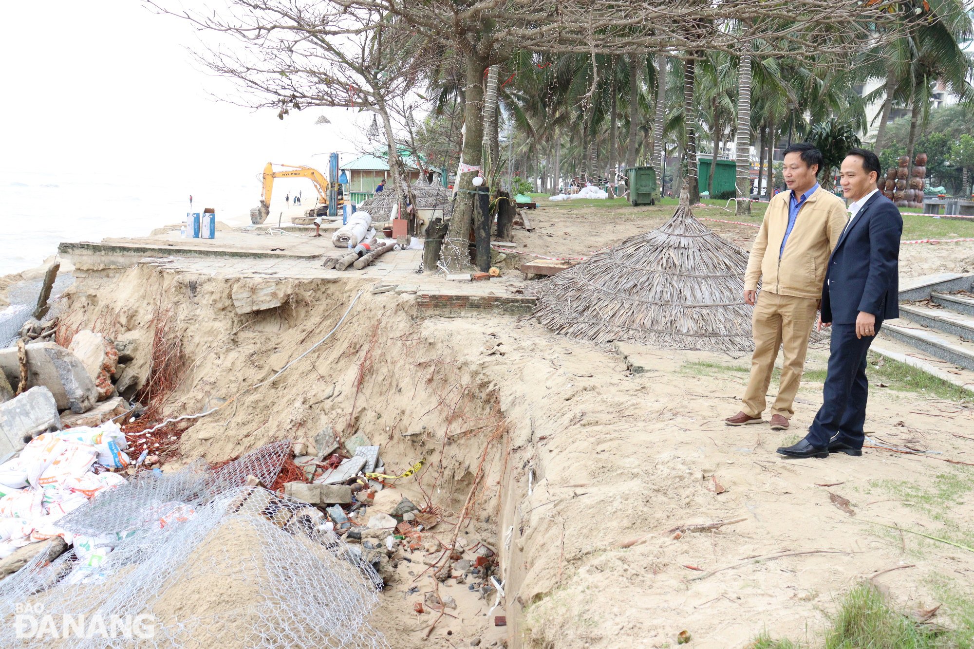 Le secrétaire adjoint permanent du Comité du Parti de la ville, Nguyen Dinh Vinh (couverture à droite), inspecte un site de glissement de terrain qui est traité d'urgence dans la zone de la plage de My Khe. Photo : HOANG HIEP