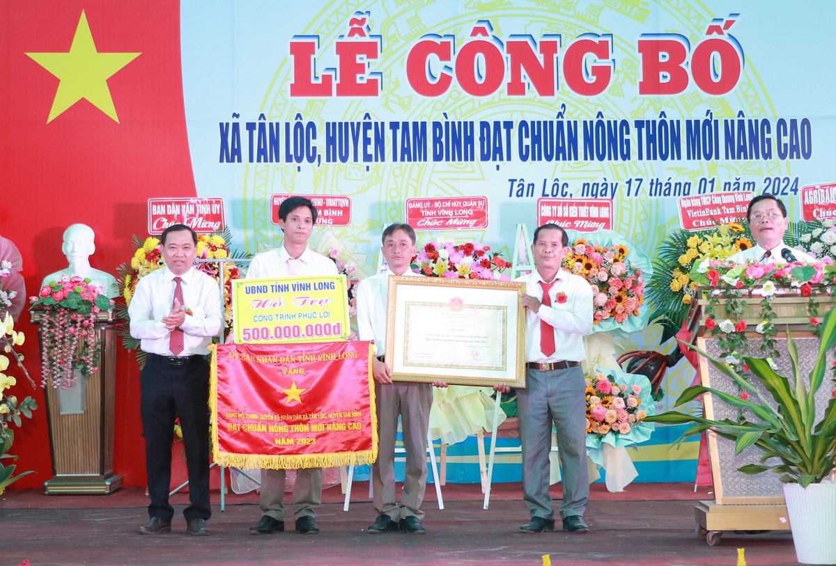 Awarding certificates of recognition and excellent emulation flags to Tan Loc advanced rural commune.