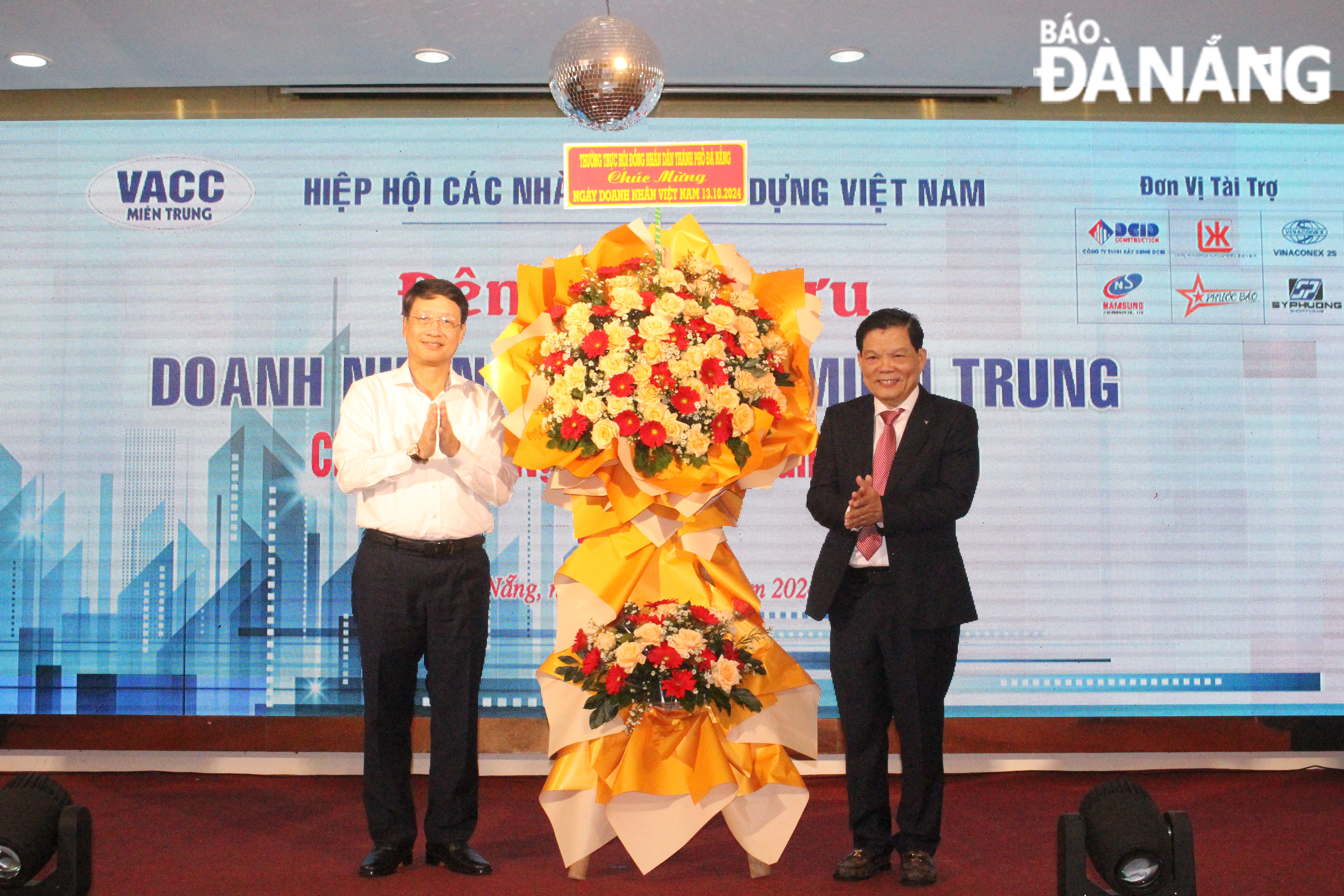 Chairman of the City People's Council Ngo Xuan Thang presented flowers to congratulate on the occasion of Vietnamese Entrepreneurs Day October 13. Photo: TRAN TRUC