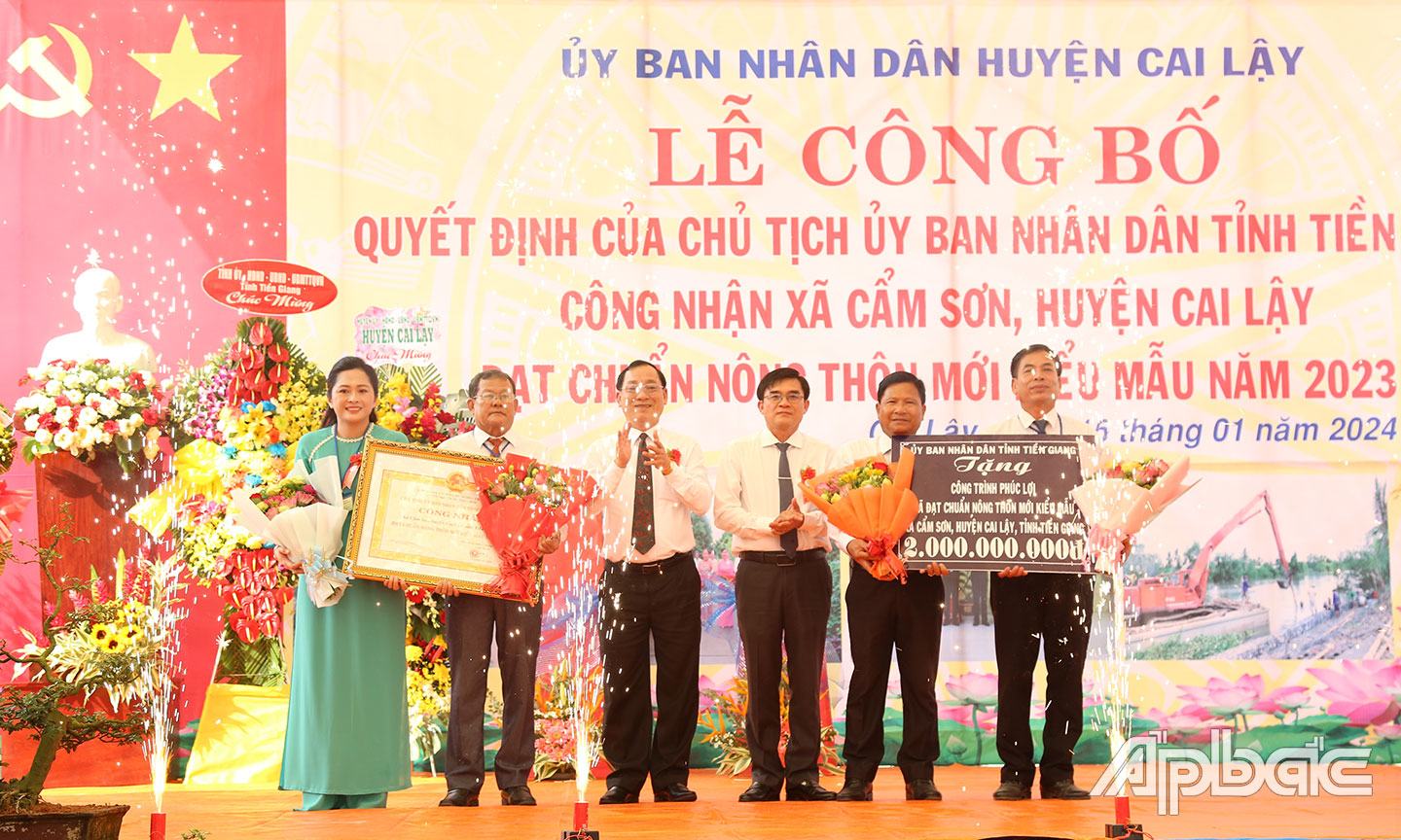 Comrade Nguyen Van Man, Director of the Department of Agriculture and Rural Development, awarded the Certificate of recognition for meeting advanced NTM standards and the symbolic plaque of donation of 500 million VND for welfare works to My Phuoc Tay commune.