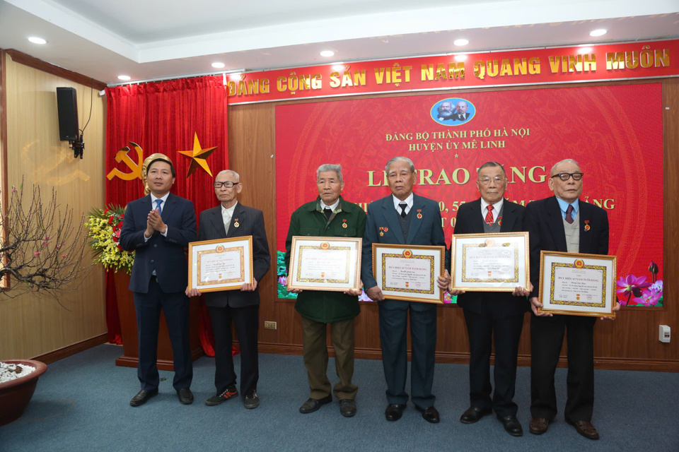 Me Linh District Party Secretary Nguyen Thanh Liem presents Party badges to party members